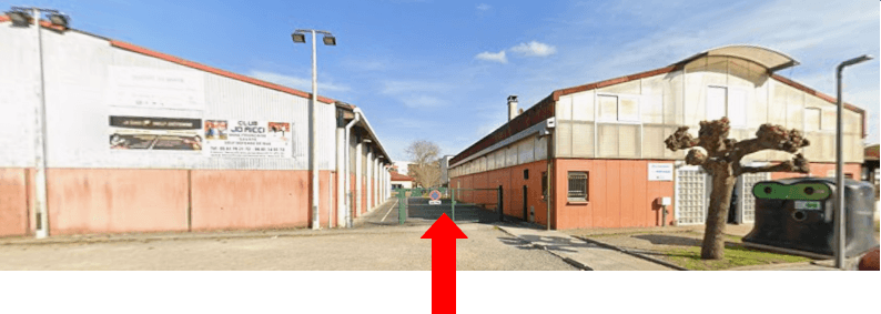 Portail vert entre le gymnase et le boulodrome, signalé par une flèche rouge